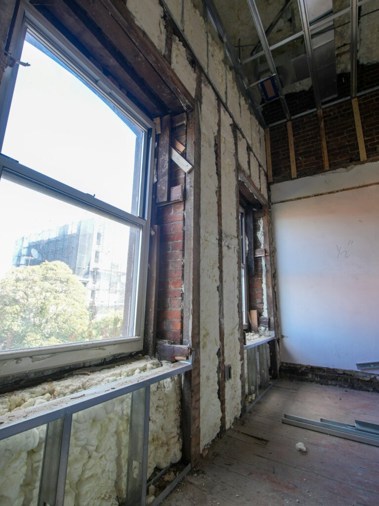 Altbau sanieren: Raum im Umbau mit freiliegendem Ziegelmauerwerk und Dämmung